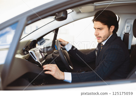 Transportation And Modern Technology Concept. Assistant checking navigation system on car dashboard screen Transportation And Modern Technology Concept. Assistant checking navigation system on car dashboard screen 125175059