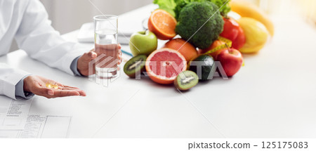 Cropped of african american woman dietologist giving pills and glass of water to female patient, food supplements concept Cropped of african american woman dietologist giving pills and glass of water to female patient, food supplements concept 125175083