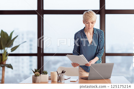 Entrepreneurship. Business Woman Checking Documents Using Laptop Working Standing In Modern Office. Free Space, Selective Focus 125175214