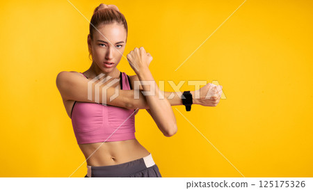 Motivated Fitness Woman Doing Arm Stretch Exercise Standing Over Pink Studio Background. Panorama 125175326