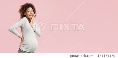 Pregnancy concept. Surprised black woman posing over pink studio background 125175370