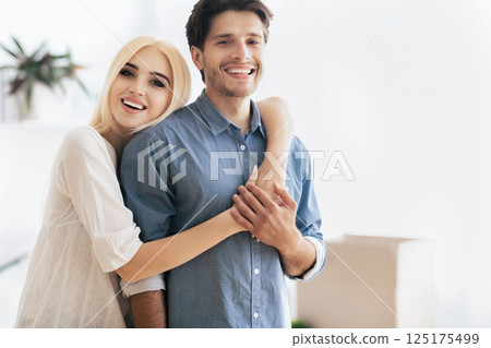 Apartment Ownership. Cheerful Couple Hugging In New House. Lovely Spouses Embracing In Own Home, Copy Space 125175499