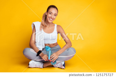Recovery After Workout Training. Fitness Girl Resting On Floor Holding Water Bottle And Towel On Pink Background. Copy Space 125175727