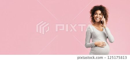 Excited pregnant woman talking on smartphone, having pleasant conversation on pink background, copy space 125175813