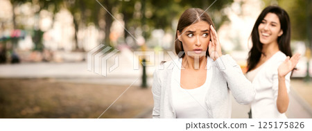 Toxic People. Girl Avoiding Meeting Tiresome Female Friend Pretending Not Noticing And Ignoring Greeting Walking Outdoors. Selective Focus 125175826