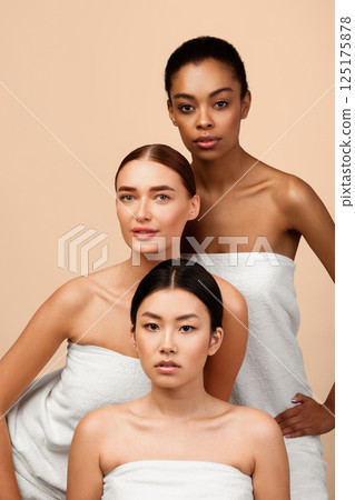 Multiethnic Beauty. Three Sensual Women With Different Types Of Skin Posing Wrapped In Towels Over Gray Background. Vertical 125175878