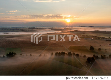Aerial drone shot of misty agricultural fields and rolling hills at sunrise Aerial drone shot of misty agricultural fields and rolling hills at sunrise 125176084