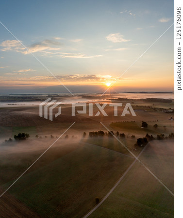 Drone aerial view with rural scenery, rolling hills covered in fog at golden hour Drone aerial view with rural scenery, rolling hills covered in fog at golden hour 125176098