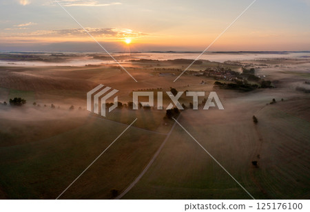 Drone image of rolling agricultural fields covered in fog at golden hour Drone image of rolling agricultural fields covered in fog at golden hour 125176100