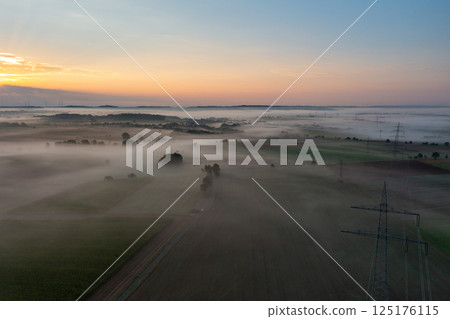 Sunrise aerial view in a german village on a foggy morning Sunrise aerial view in a german village on a foggy morning 125176115