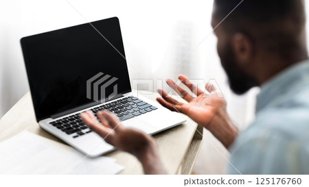 No way. Worried african american guy looking at laptop with blank screen. Over shoulder shot, selective focus on device 125176760