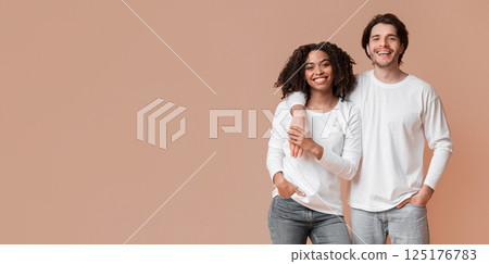 Happy interracial couple cuddling while posing over yellow background, loving man embracing his afro girlfriend, free space Happy interracial couple cuddling while posing over yellow background, loving man embracing his afro girlfriend, free space 125176783