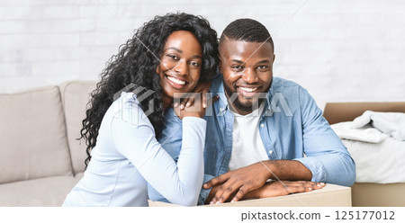 New life in new house. Young happy african american couple embracing at new apartment, copy space 125177012