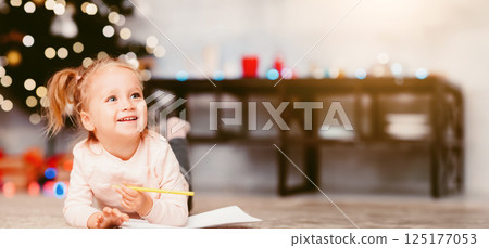 Christmas fun. Adorable little kid lying on floor near Xmas tree, empty space Christmas fun. Adorable little kid lying on floor near Xmas tree, empty space 125177053