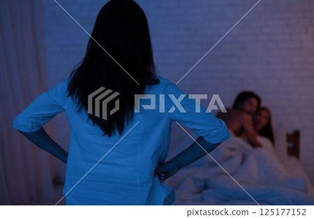 Cheating. Girl Catching Unfaithful Boyfriend With Another Woman In Bed Making Love In Bedroom. Low Light, Selective Focus 125177152