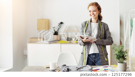 Fashion designer drawing new sketches collection on tablet, working in designers stylish showroom Fashion designer drawing new sketches collection on tablet, working in designers stylish showroom 125177296