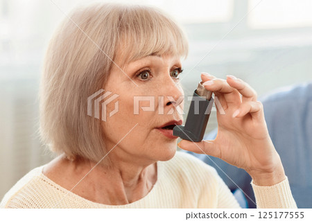 Senior Woman Using Asthma Inhaler For Allergies In Modern Clinic, Copy Space Senior Woman Using Asthma Inhaler For Allergies In Modern Clinic, Copy Space 125177555