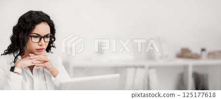 Analysing Work. Focused mexican woman using laptop, doing some research. Copy space 125177618