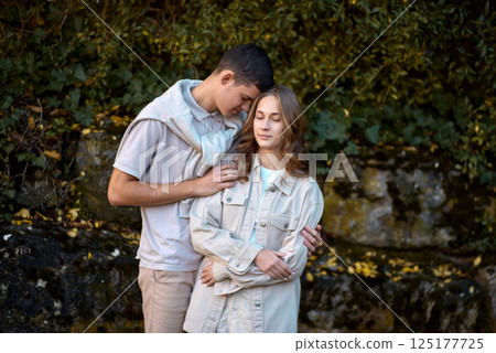 Embracing Teen Love in the Greenery of the Park. 125177725