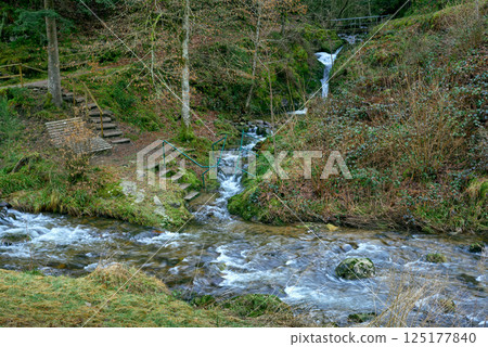 Majestic Allerheiligen Waterfalls: Serene Long Exposure Cascade in Black Forest National Park Germany. Scenic Forest Stream Flows Through Lush Greenery and Moss Covered Rocks Creating Ethereal 125177840