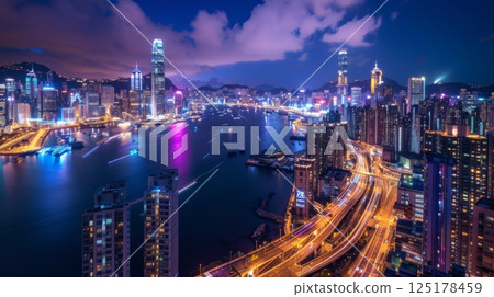 An aerial view of Hong Kong's skyline at night, showcasing the city's vibrant lights and bustling harbor. 125178459