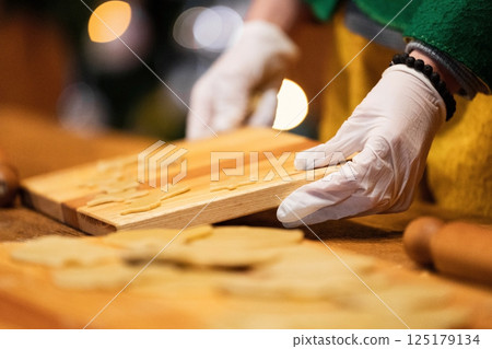 Hands Preparing Christmas Cookies with Gloves 125179134
