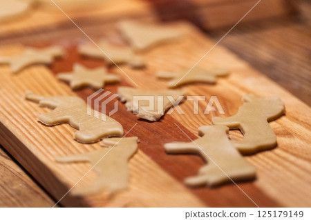 Raw Christmas Cookies on Wooden Cutting Board 125179149