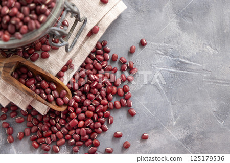 Glass jar full of dried azuki beans with a wooden scoop top view. Vegetarian protein source 125179536