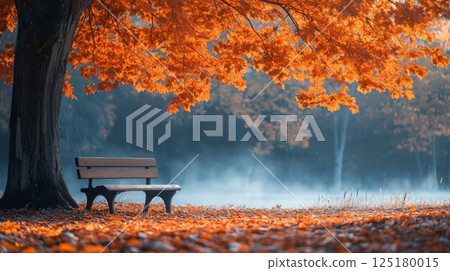A peaceful park scene features a bench placed beneath a vibrant orange maple tree, with fallen leaves covering the ground, creating a calming atmosphere at dawn. 125180015