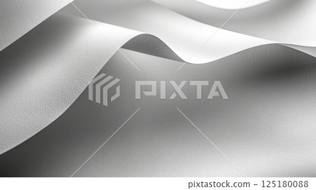 Smooth white fabric undulates softly, catching light in gentle waves, creating an elegant and serene atmosphere perfect for showcasing textiles. 125180088