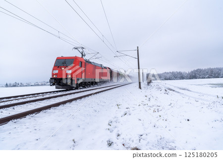Train traveling through snow, winter scenery in Germany 125180205