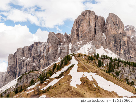 Scenic mountain landscape with snow patches and rocky peaks under blue sky near Valley of Funes at Dolomites, Italy Scenic mountain landscape with snow patches and rocky peaks under blue sky near Valley of Funes at Dolomites, Italy 125180603