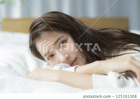 A woman lying on the bed 125181308