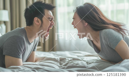 Couple sitting on their bed and arguing to each other Couple sitting on their bed and arguing to each other 125181390