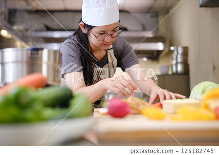 Focused chef carefully a gourmet sandwich in a professional kitchen with fresh ingredients in view Focused chef carefully a gourmet sandwich in a professional kitchen with fresh ingredients in view 125182745