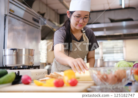 Focused chef preparing clean food ingredients from organic farm produce in a professional kitchen. Focused chef preparing clean food ingredients from organic farm produce in a professional kitchen. 125182747