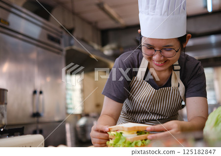 Chef with a eggs sandwich ready for plating Chef with a eggs sandwich ready for plating 125182847