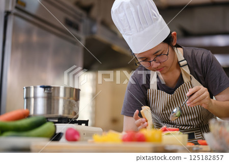 Focused chef carefully a gourmet sandwich in a professional kitchen with fresh ingredients in view Focused chef carefully a gourmet sandwich in a professional kitchen with fresh ingredients in view 125182857