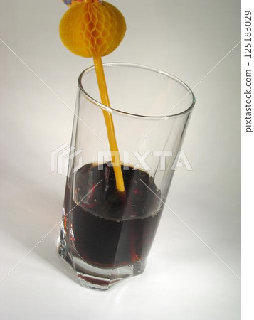 Dark Grape Juice In A Glass With a Straw 125183029