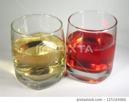Red and white wine in transparent glasses over white background Red and white wine in transparent glasses over white background 125183060