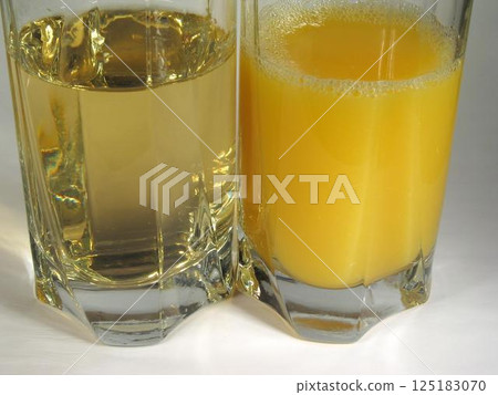 Apple and orange juice in transparent glasses Apple and orange juice in transparent glasses 125183070