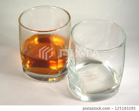 Glass of whisky and empty glass close view background 125183295