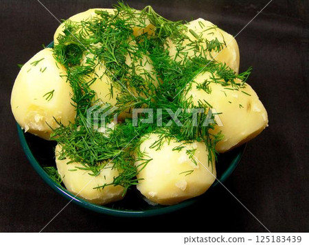 Boiled potatoes with greens decoration close view background 125183439
