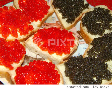 Red and black caviar over red background 125183476
