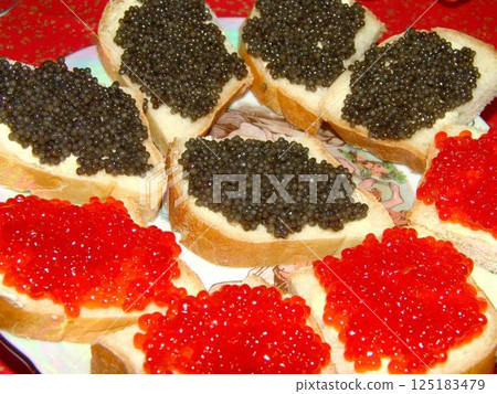 Red and black caviar over red background Red and black caviar over red background 125183479