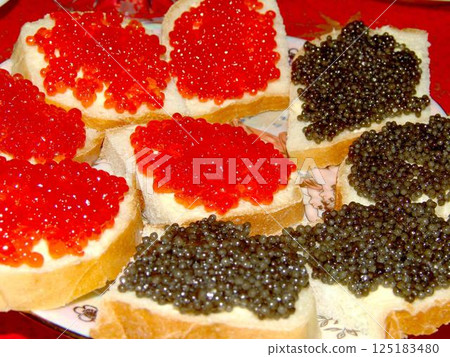 Red and black caviar over red background 125183480