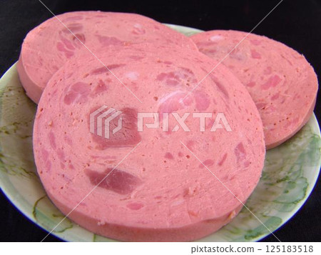Slices of sausage on a plate close view 125183518