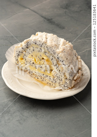 Deliciously crafted poppy seed cake roll with creamy filling served on a white plate 125183641