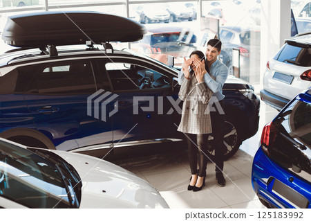 Surprise Concept. Husband Covering Wife's Eyes After Buying Her Brand New Auto In Dealership Store. Empty Space 125183992