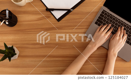 Top View Of Office Workplace. Young secretary working at wooden desk, copyspace for text or logo Top View Of Office Workplace. Young secretary working at wooden desk, copyspace for text or logo 125184027
